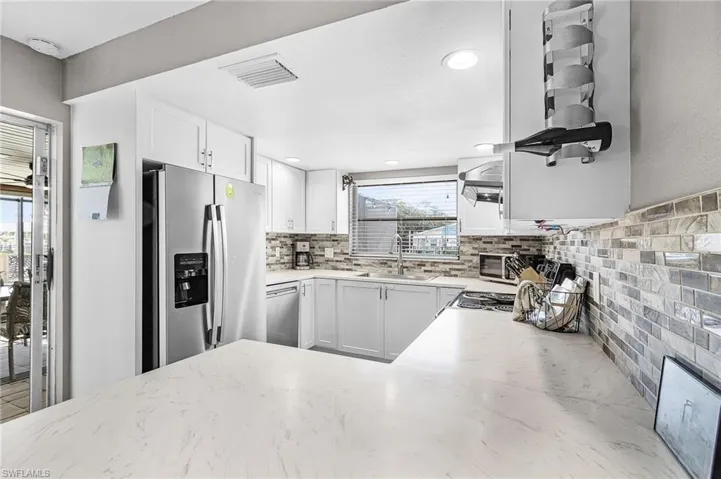 Pocket slider from kitchen to pool deck.  Solid surface counters in the kitchen with stainless steel appliances.