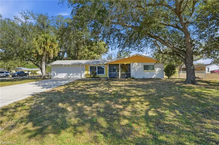 Ranch-style house featuring concrete driveway and an attached garage
