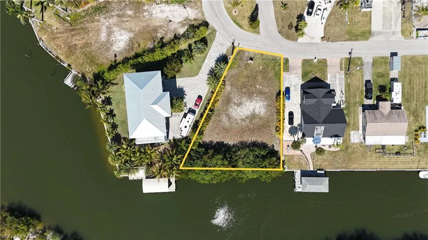 Aerial overview of property's location with a large body of water and property parcel outlined