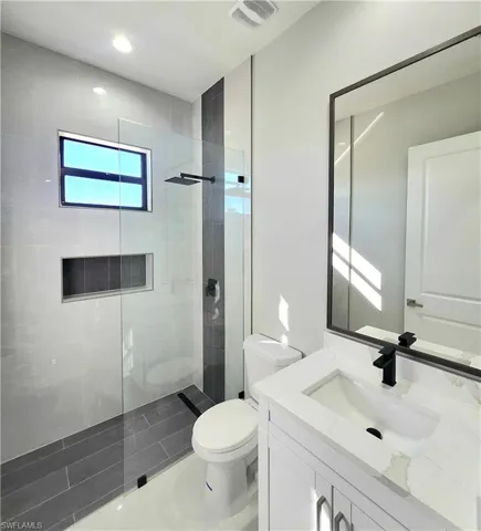 Full bath featuring walk in shower, vanity, and recessed lighting