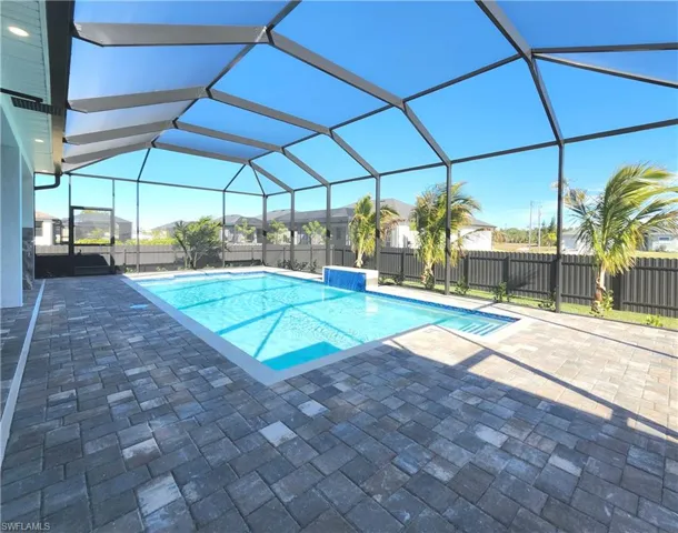 View of swimming pool featuring a sunroom, glass enclosure, a patio area, a fenced backyard, and a residential view
