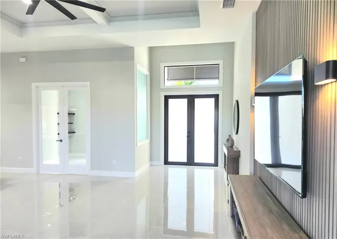 Foyer entrance featuring french doors, plenty of natural light, a towering ceiling, and a ceiling fan