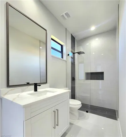 Bathroom with vanity, a shower stall, and recessed lighting