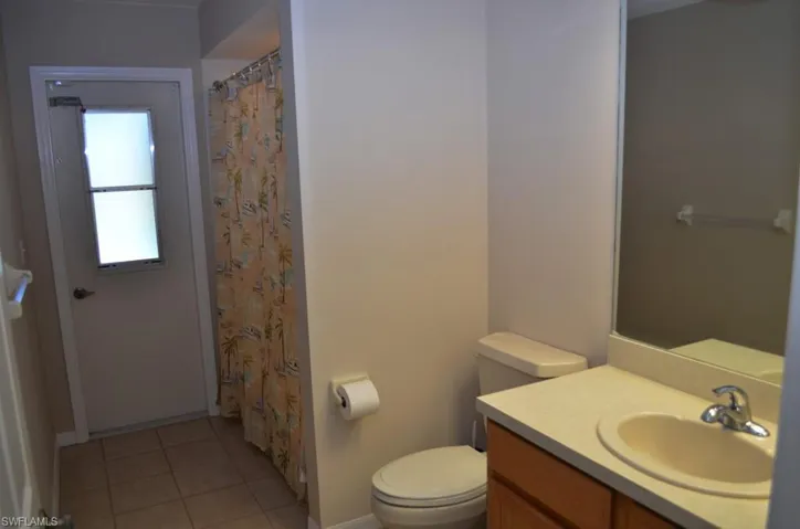Bathroom featuring tile patterned floors, vanity, and toilet