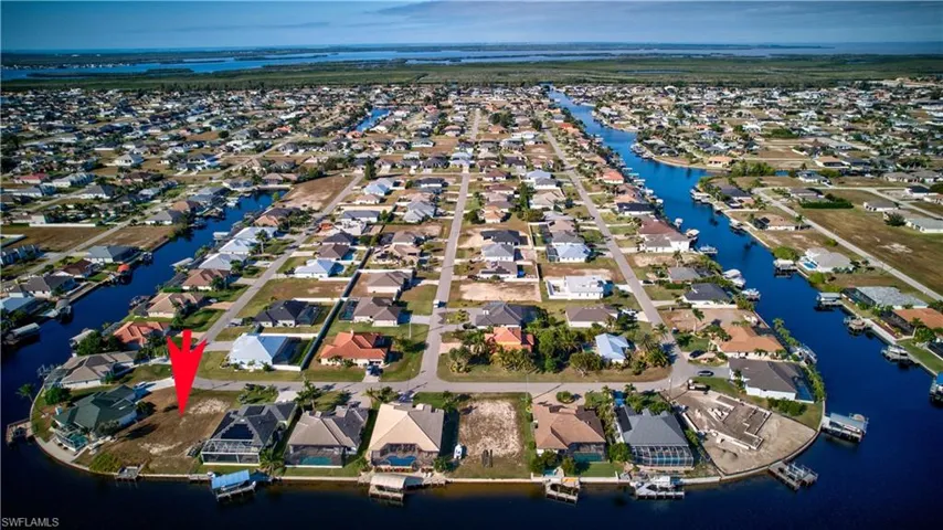 Aerial view of property's location with a nearby body of water and nearby suburban area
