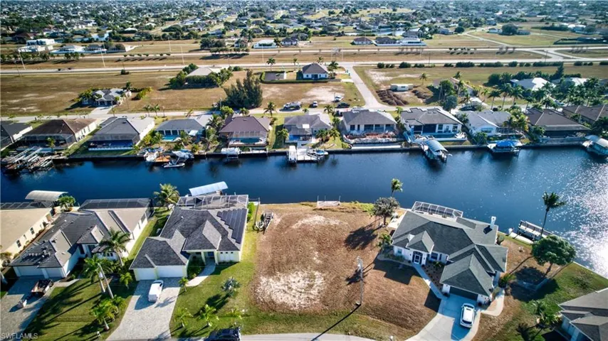 Aerial view of property and surrounding area with nearby suburban area and a nearby body of water
