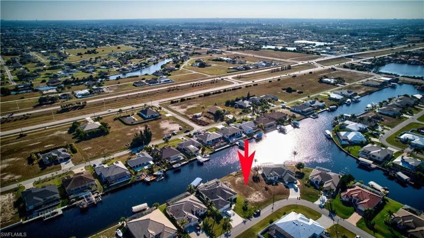 Aerial view of property and surrounding area featuring a nearby body of water and nearby suburban area