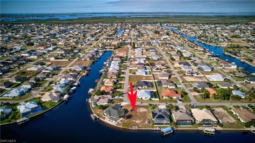Aerial overview of property's location featuring a nearby body of water and nearby suburban area