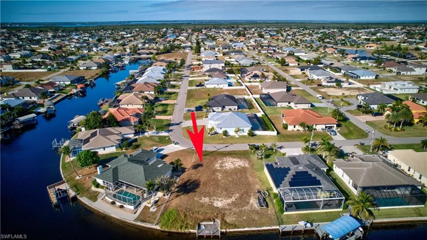 Aerial view of property's location featuring a nearby body of water and nearby suburban area