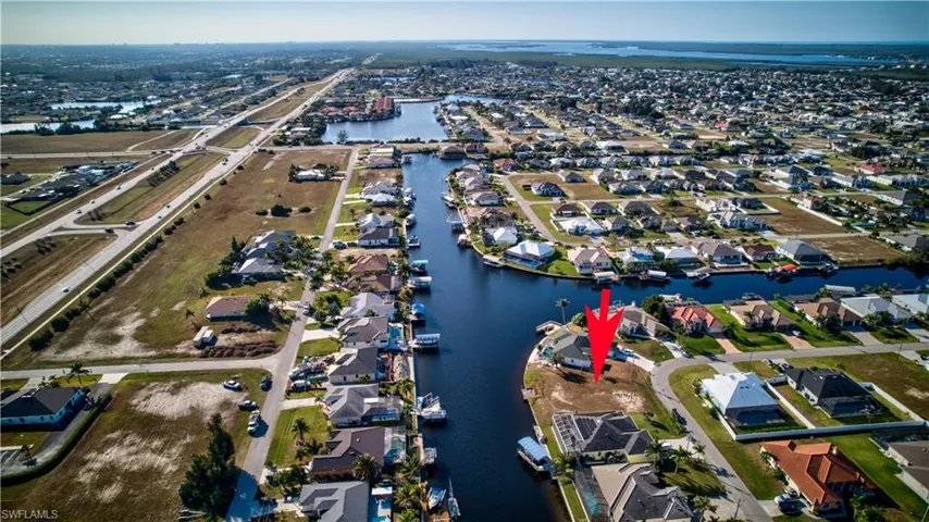 Aerial view of property's location with a nearby body of water and nearby suburban area