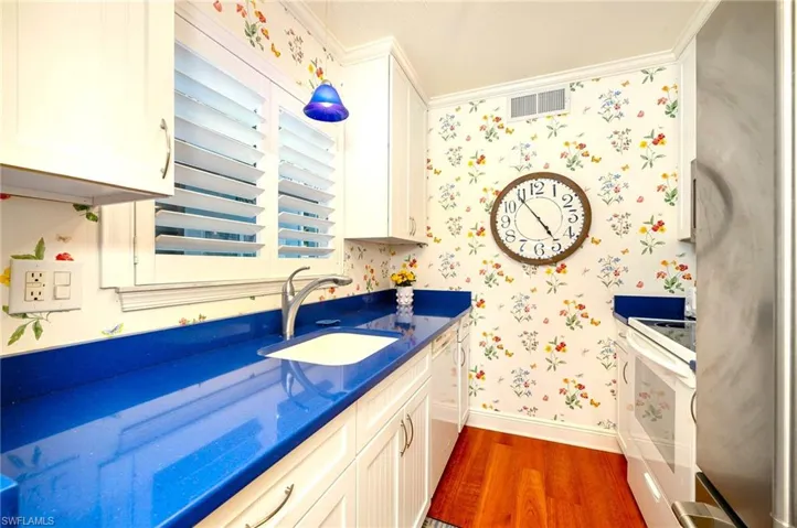 Bathroom featuring crown molding, sink, and hardwood / wood-style floors