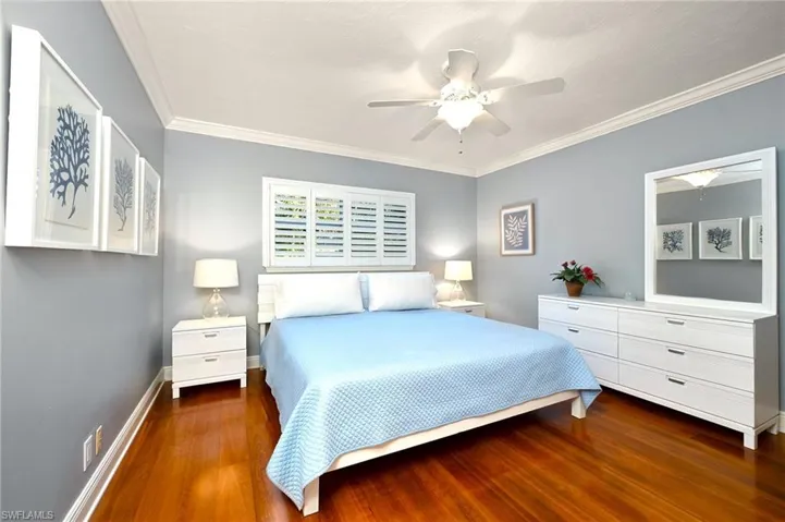 Bedroom featuring ceiling fan, ornamental molding, and dark hardwood / wood-style flooring