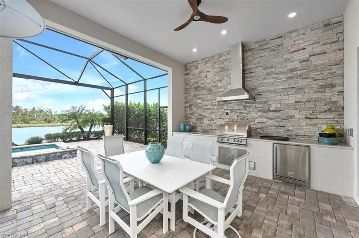 View from patio/terrace overlooking spa and canal.  Commercial style SS gas grill, refrigerator and sink.