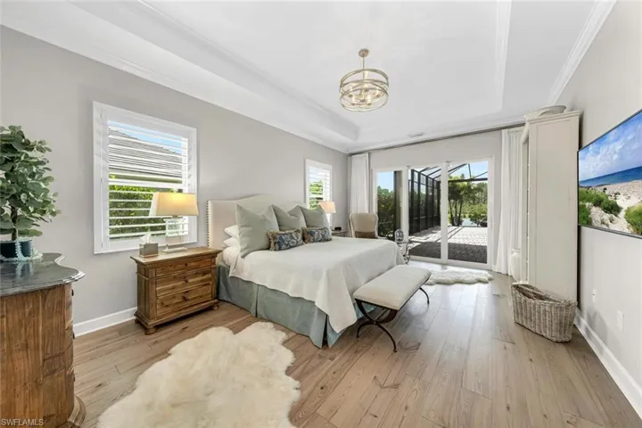 Retreat to the master suite with plantation shutters, separate entrance to the lanai, and distinguished chanderlier.
