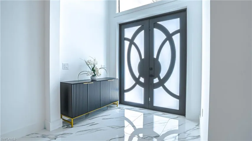 Foyer entrance featuring marble finish flooring and french doors