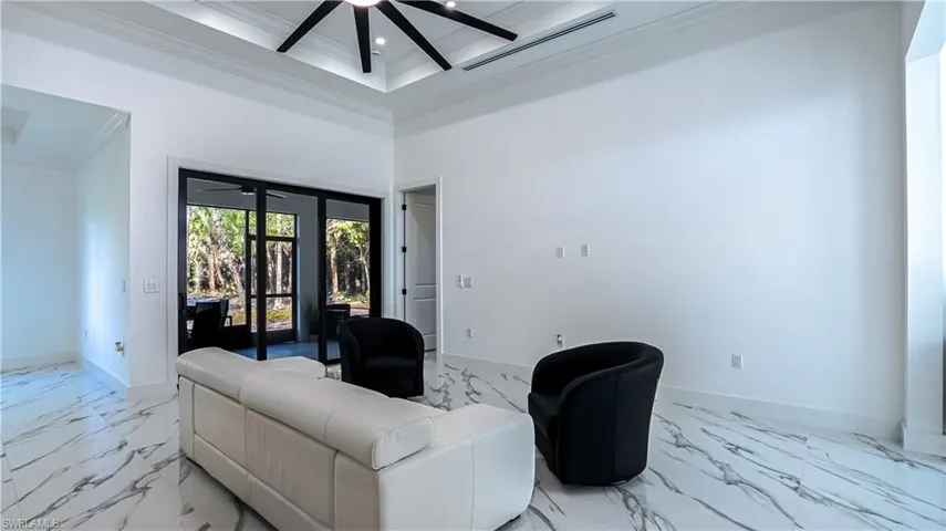 Living area with marble finish flooring, crown molding, a towering ceiling, ceiling fan, and recessed lighting