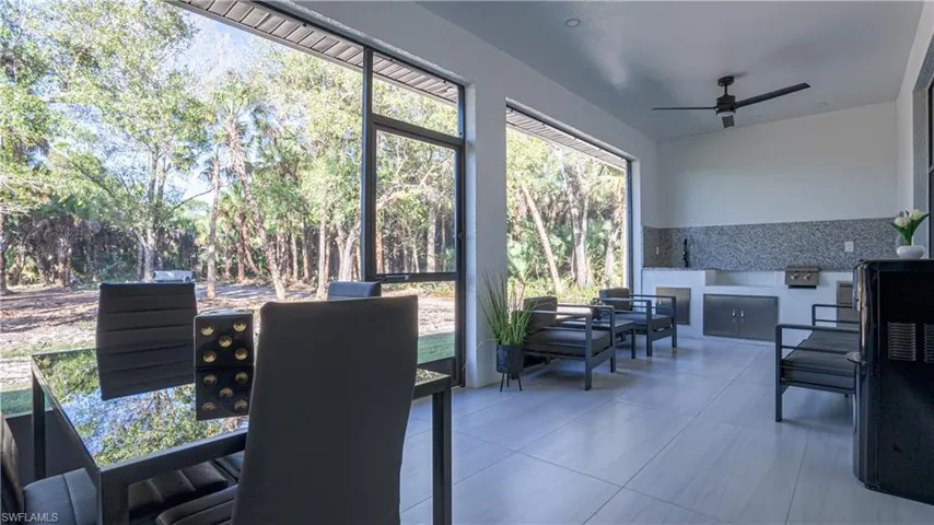 Sunroom with tile patterned floors and view of scattered trees