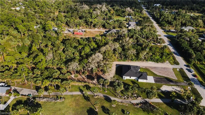 Aerial view of property and surrounding area with a forest