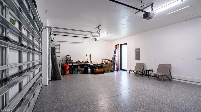 Garage featuring electric panel and a garage door opener