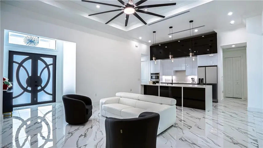 Living room with light marble finish flooring, ornamental molding, french doors, ceiling fan, and recessed lighting