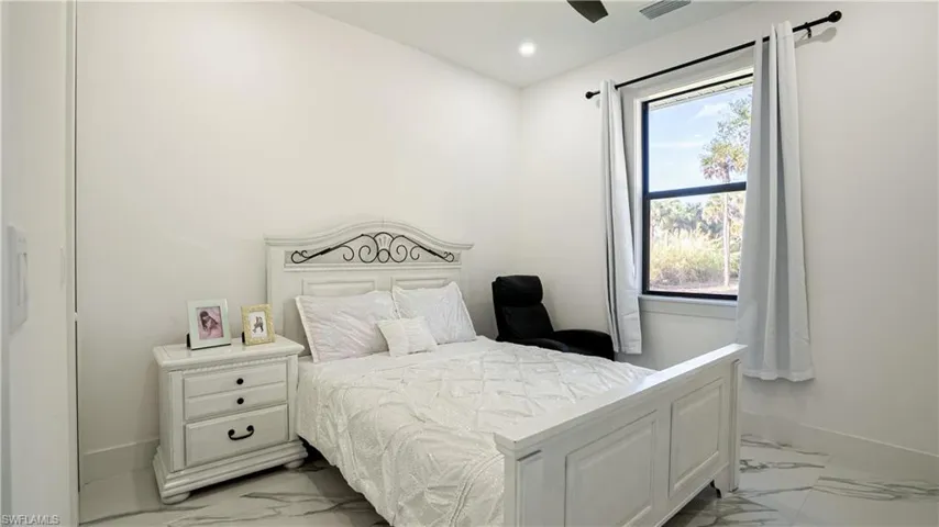 Bedroom featuring light marble finish floors and recessed lighting