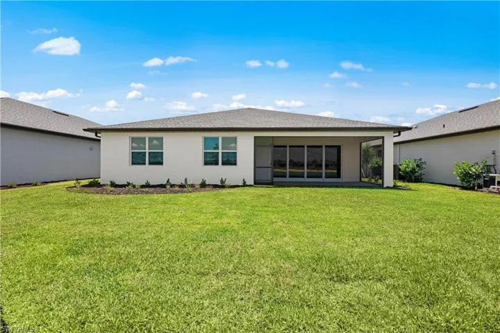 Back of property with a lawn
