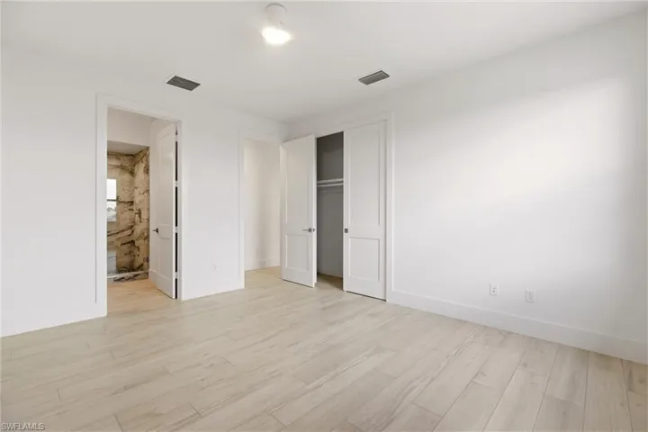 Unfurnished bedroom with light wood finished floors and a closet