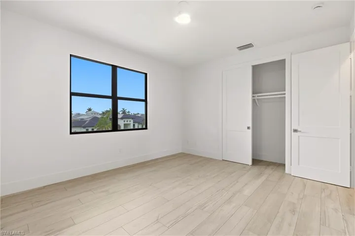 Unfurnished bedroom featuring light wood finished floors and a closet