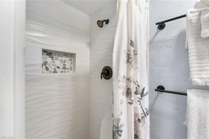 Bathroom featuring curtained shower