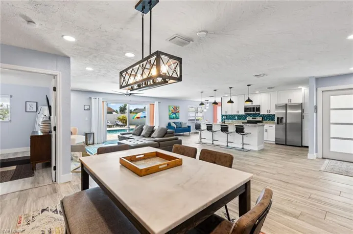 Dining space with light hardwood / wood-style floors and a textured ceiling