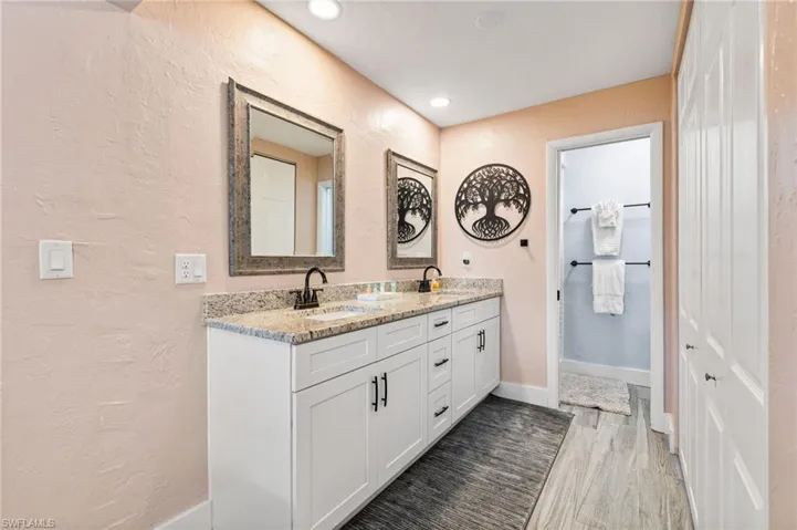 Bathroom featuring hardwood / wood-style flooring and dual vanity