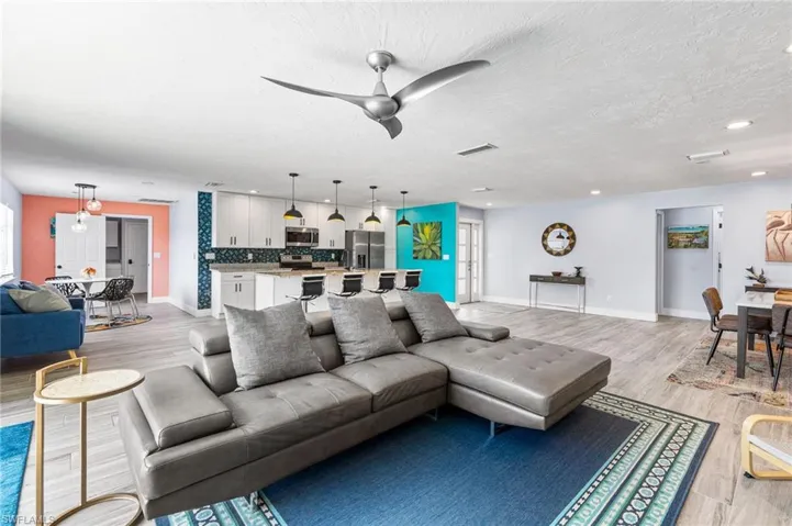 Living room featuring a textured ceiling, light wood-type flooring, and ceiling fan