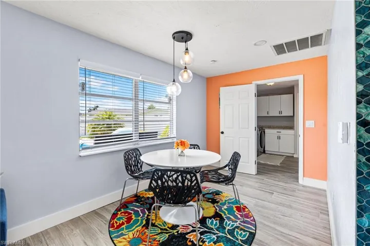 Dining area with washer / clothes dryer and light hardwood / wood-style flooring
