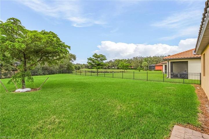 HUGE fenced in back yard featuring a lake view . . .