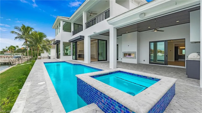 View of swimming pool with a ceiling fan, a balcony, a patio area, and a pool with connected hot tub