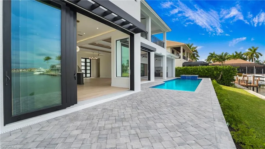 Swimming pool with a balcony, a patio, and ceiling fan