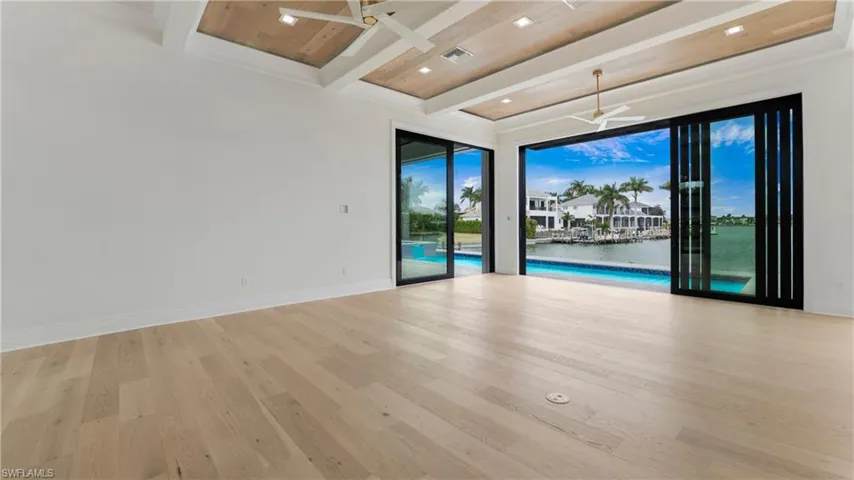 Unfurnished room with wood finished floors, a water view, recessed lighting, a ceiling fan, and a wood ceiling with exposed beams