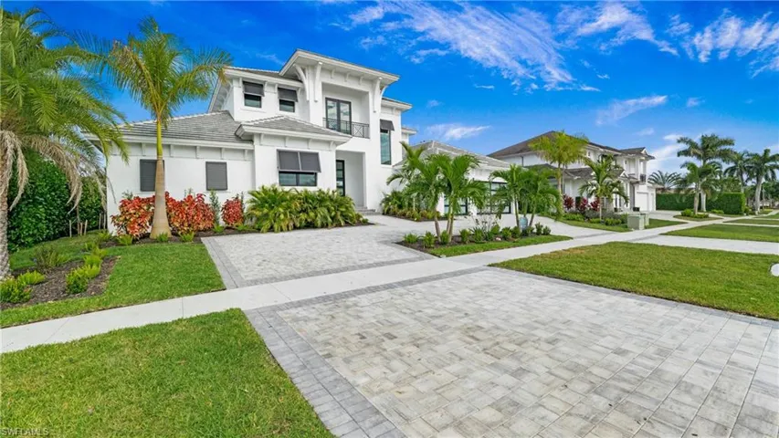 View of front of home with a front yard, stucco siding, and a tiled roof