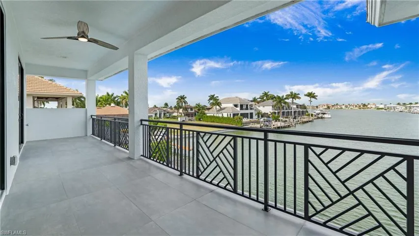 Balcony featuring ceiling fan, a water view, a residential view, and a sunroom