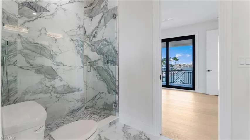 Full bathroom with a marble finish shower and light marble finish flooring