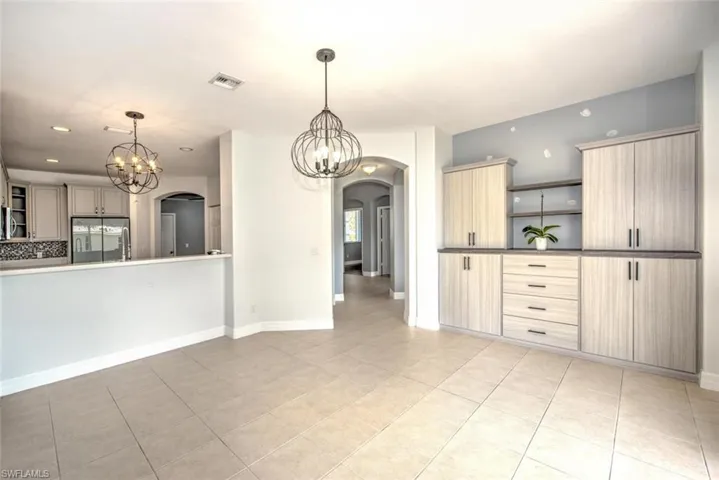 Kitchen with refrigerator, open shelves, visible vents, an inviting chandelier, and light brown cabinetry