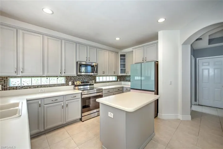 Kitchen featuring stainless steel appliances, gray cabinetry, and light tile patterned floors