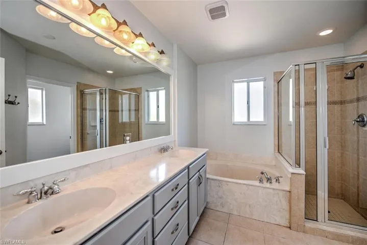 Bathroom featuring a bath, a shower stall, and a sink