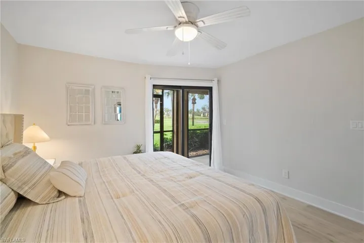 Bedroom with access to exterior, light wood-type flooring, and ceiling fan