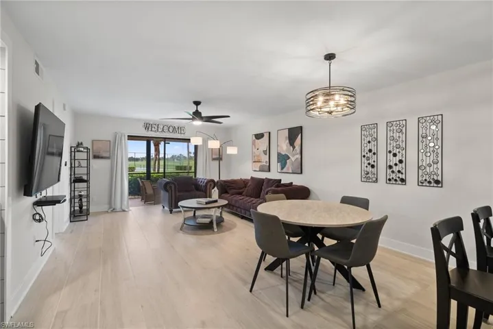 Dining room featuring ceiling fan with notable chandelier and light hardwood / wood-style flooring