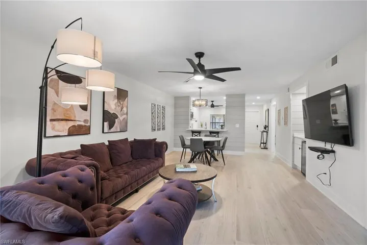 Living room featuring light hardwood / wood-style floors and ceiling fan with notable chandelier