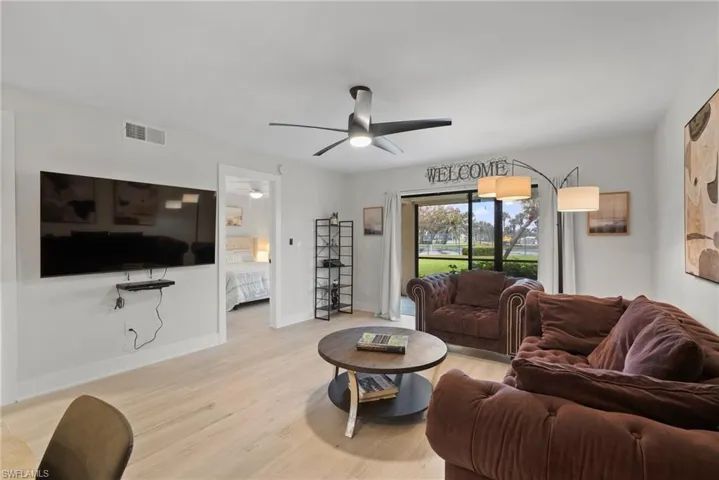 Living room with light hardwood / wood-style flooring and ceiling fan