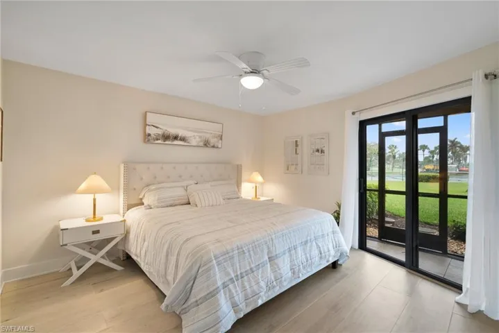 Bedroom featuring access to outside, hardwood / wood-style floors, and ceiling fan