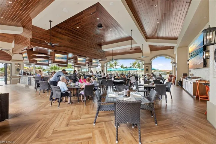 Open-air dining area featuring wood-finish flooring in a herringbone pattern and a wood-paneled vaulted ceiling