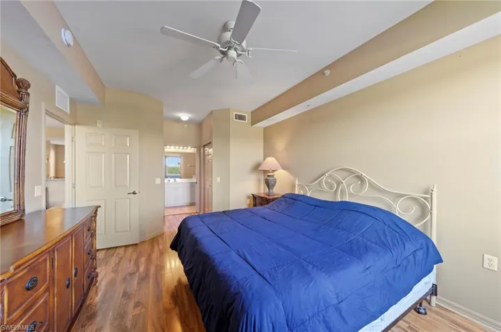 Spacious room featuring wood-finish flooring, a ceiling fan, and light neutral wall tones